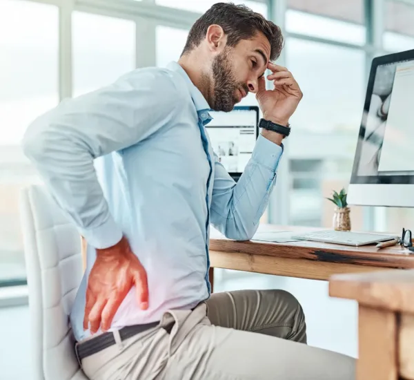 Patient fasst sich an den Rücken